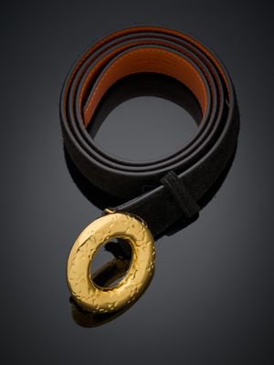 une ceinture noire et dorée avec une boucle dorée sur fond noir