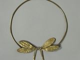 Collier avec une libellule dorée sur fond blanc