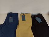 three pairs of men ' s pants sitting on a white surface