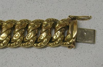 un bracelet en or muni d'une chaîne, posé sur une table