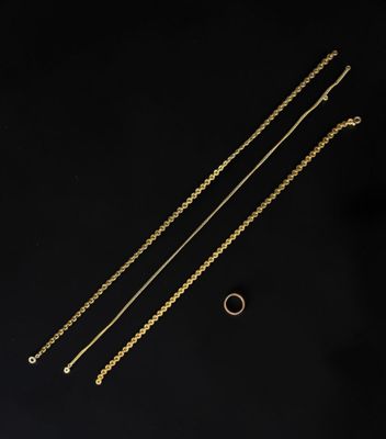 trois chaînes en or et une bague sur fond noir