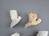four ceramic figurines of birds on a gray surface