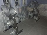 une photo d'une salle de sport avec un râtelier d'haltères