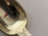 a silver spoon with a spoon handle on a table