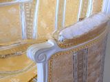 a chair that has a yellow and white striped upholstered back