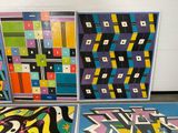 several pieces of art are on display in front of a white wall