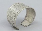 a close up of a silver bracelet on a white surface