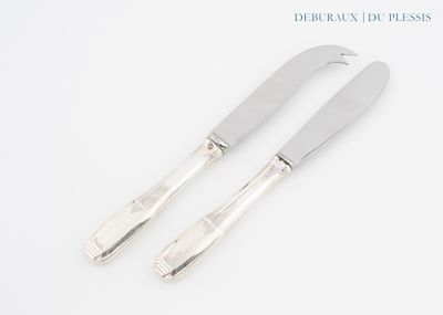 pair of silver plated cheese knives on a white surface