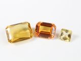 trois pierres précieuses de couleurs différentes posées sur une surface blanche