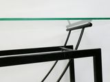 une table en verre avec un cadre en métal et un plateau en verre