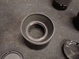 a camera lens sitting on a table next to a cup of coffee