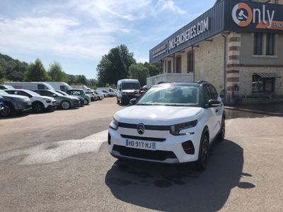 the white car is parked in front of a building with many cars parked in front of it