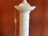 une lampe posée sur un socle au sol