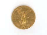 une pièce d'or sur laquelle est représenté un ange, sur un fond blanc