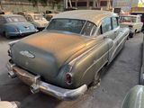 many old cars parked in a parking lot next to each other