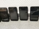 six cell phones are lined up in a row on the floor