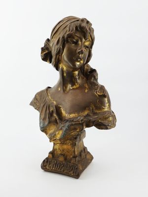 un buste en bronze représentant une femme vêtue d'une robe et tenant une fleur