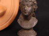a small statue of a woman next to a carved object