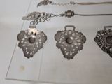 a lot of silver jewelry on display on a table