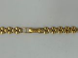 a close up of a gold bracelet on a white surface