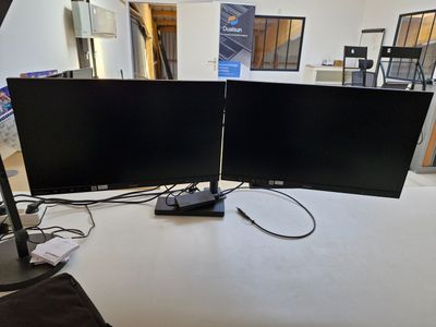 deux écrans posés sur une table, avec une lampe