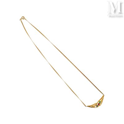 un gros plan sur un collier en or orné de pierres vertes