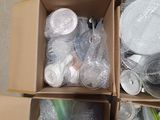 two boxes filled with plastic bottles and containers on the ground
