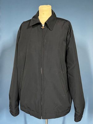 a black jacket on a mannequin stand against a blue background