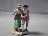 une figurine représentant un homme et une femme debout sur un rocher