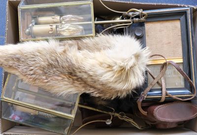 une boîte remplie d'objets divers, notamment un bonnet en fourrure, un sac à main et d'autres articles