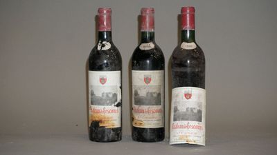 trois bouteilles de vin posées sur une table l'une à côté de l'autre