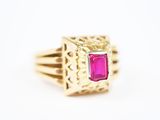 gros plan d'une bague en or avec une pierre rose