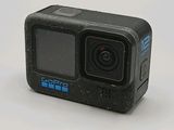 a small black action camera sitting on a white surface