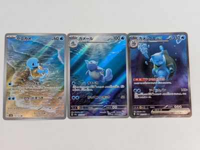 trois cartes pokemon posées les unes sur les autres sur une table