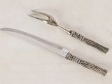 two forks and a knife sitting on a table
