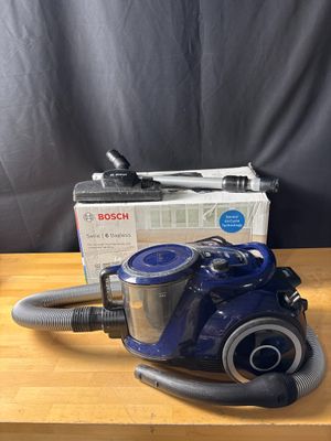 un aspirateur bleu posé sur une table en bois