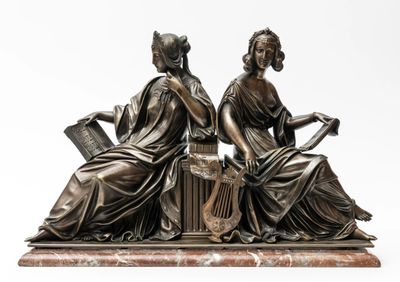 two bronze statues of women sitting on a marble base