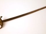 une vieille épée avec un manche en bois sur une surface blanche