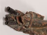 a statue of a hand holding a pipe on a white surface
