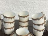several cups and saucers sitting on a table with a white wall in the background
