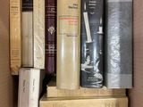 many books in a box that are stacked together