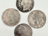 Quatre pièces de monnaie britanniques différentes sont représentées sur un fond blanc.