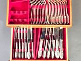 a lot of silverware in a wooden box on a table