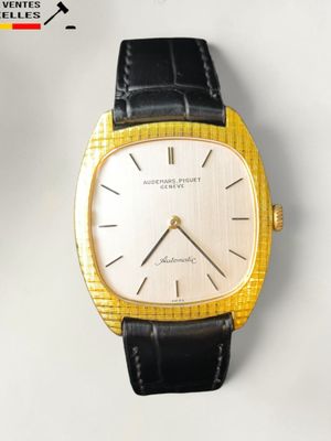 une montre-bracelet en or avec un bracelet en cuir noir