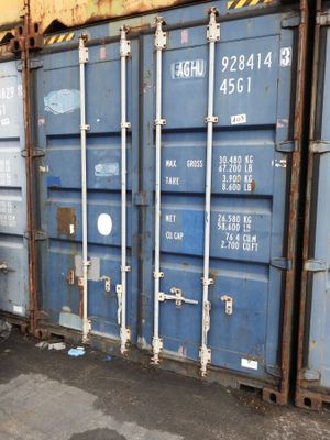 a blue shipping container sitting on the side of the road