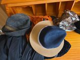 several hats are lined up on a wooden floor next to a crib