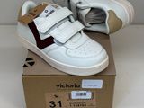 une boîte sur laquelle est posée une paire de chaussures blanches