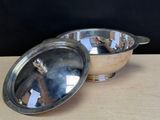 a silver bowl with a lid sitting on a table