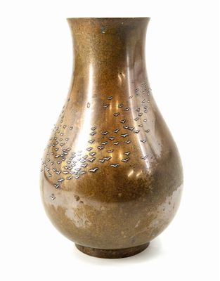 a brown vase that is sitting on a white surface