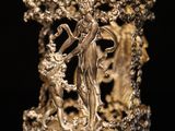 a gold plated figurine of a woman and a man in a garden